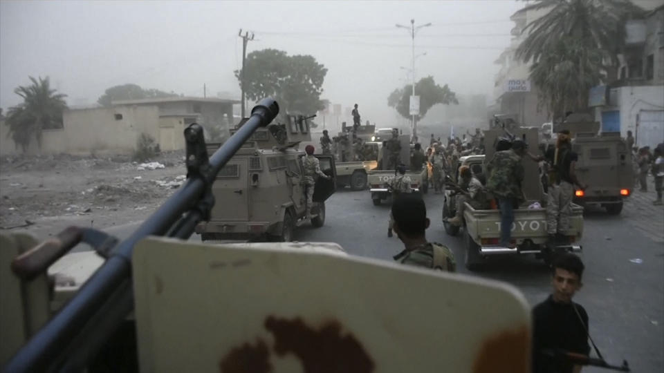 In this Friday Aug. 9, 2019 frame grab from video, Southern Transitional Council separatist fighters line up to storm the presidential palace in the southern port city of Aden, Yemen. The separatists backed by the United Arab Emirates began withdrawing Sunday from positions they seized from the internationally-recognized government in Aden. Both the southern separatists and the government forces are ostensibly allies in the Saudi-led military coalition that’s been battling the Houthi rebels in northern Yemen since 2015, but the four days of fighting in Aden have exposed a major rift in the alliance. (AP Photo)