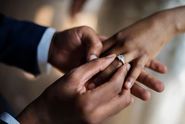 <p>Getty</p> Groom putting ring on bride's hand