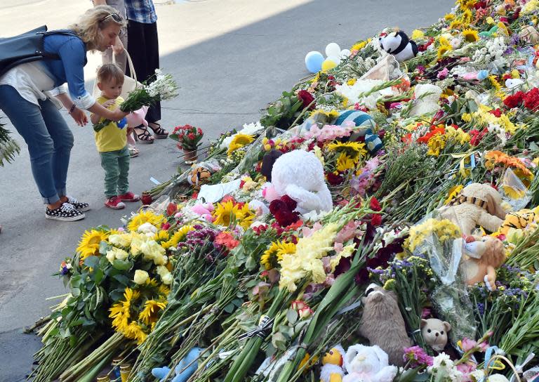 A woman and her son lay flowers outside the Dutch embassy in Kiev, on July 21, 2014