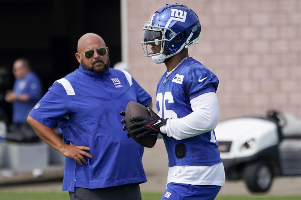 New York Giants running back Saquon Barkley walks the field alongside head coach Brian Daboll, left, during training camp at the NFL football team's practice facility, Thursday, July 28, 2022, in East Rutherford, N.J. (AP Photo/John Minchillo)