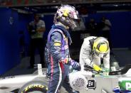 Red Bull Formula One driver Sebastian Vettel of Germany (L) carries a fan to his car after parking at the completion of the qualifying session of the Indian F1 Grand Prix at the Buddh International Circuit in Greater Noida, on the outskirts of New Delhi, October 26, 2013. REUTERS/Anindito Mukherjee (INDIA - Tags: SPORT MOTORSPORT F1)