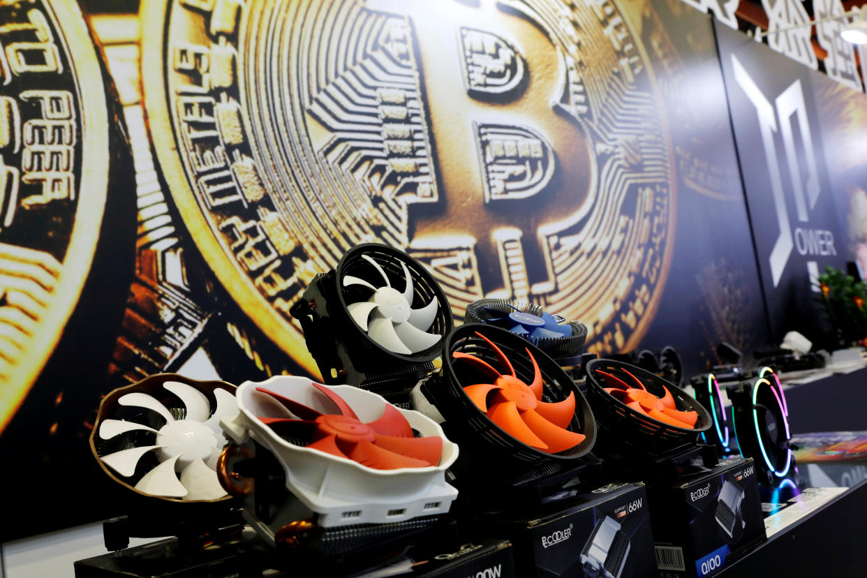 Cryptocurrency mining computer fans are seen in front of bitcoin logo during the annual Computex computer exhibition in Taipei, Taiwan June 5, 2018. REUTERS/Tyrone Siu