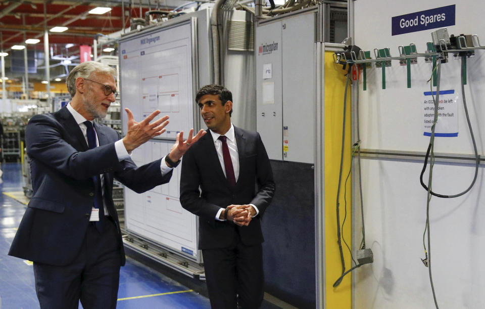 Britain's Chancellor of the Exchequer Rishi Sunak talks with the CEO of Worcester Bosch, Carl Arntzen, left, during a visit to Worcester Bosch factory to promote the initiative, Plan for Jobs, in Worcester, England, Thursday July 9, 2020. (Phil Noble/Pool via AP)