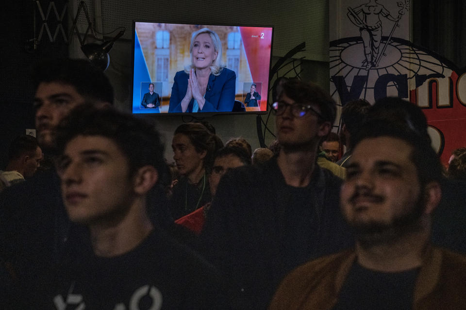 Marine Le Pen is seen on a television screen at a bar in Paris as people watch the presidential debate between President Emmanuel Macron and Le Pen on Wednesday, April 20, 2022. (Sergey Ponomarev/The New York Times)