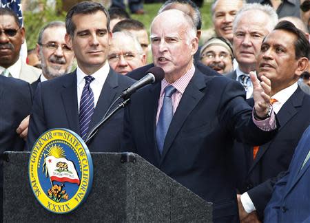 California Governor Jerry Brown (C) speaks during ceremonies before signing AB60 into law in Los Angeles October 3, 2013. REUTERS/Fred Prouser