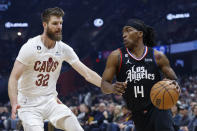 Los Angeles Clippers guard Terance Mann (14) drives against Cleveland Cavaliers forward Dean Wade (32) during the first half of an NBA basketball game, Sunday, Jan. 29, 2023, in Cleveland. (AP Photo/Ron Schwane)