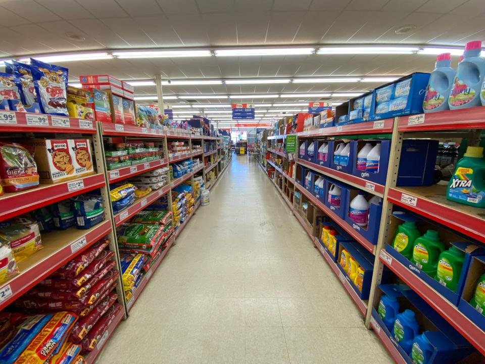 A wide aisle with products on shelves at save a lot