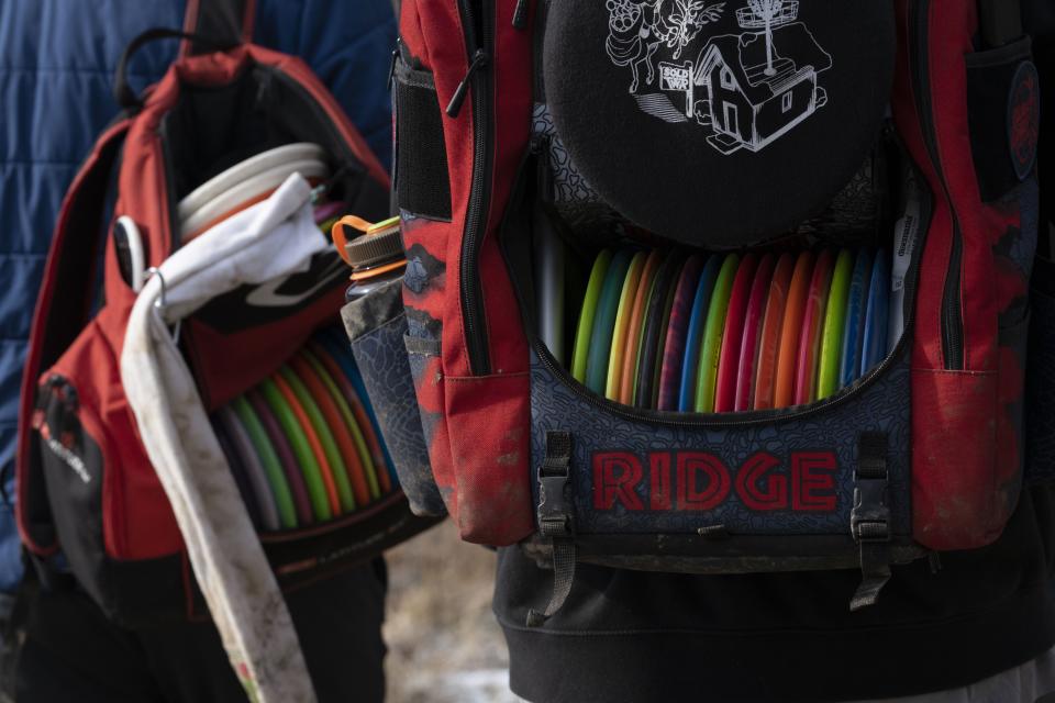 Two backpacks filled with special discs used to play disc golf.