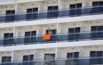 A passenger waves from MSC Fantasia cruise ship in Lisbon