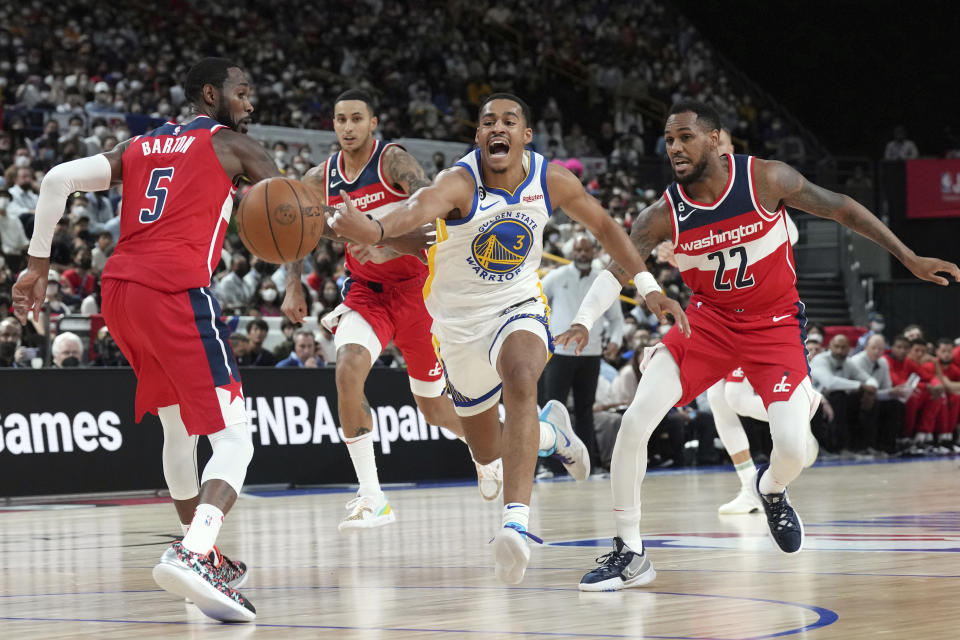 Golden State Warriors' Jordan Poole, center, goes after the ball during a preseason NBA basketball game, Sunday, Oct. 2, 2022, at Saitama Super Arena, in Saitama, north of Tokyo. (AP Photo/Eugene Hoshiko)