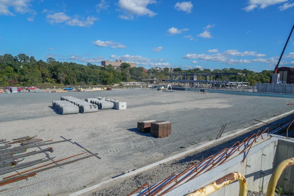 Concrete pipe sections are stored on what will be the soccer pitch when construction is finished. This view is from where box seats will hold fans.