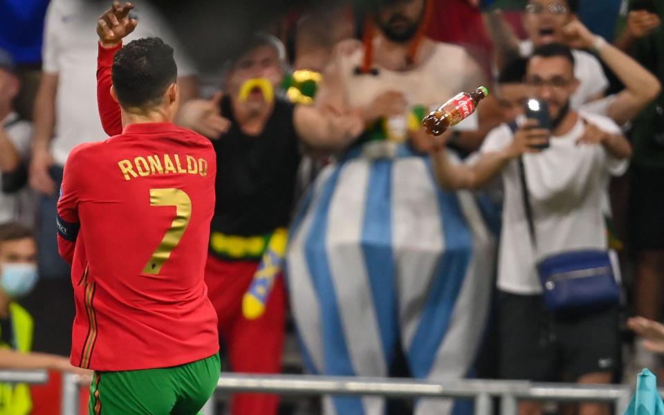Portugal's Cristiano Ronaldo celebrates after converting a penalty kick, a bottle of Coke flies in his direction on the right - ROBERT MICHAEL/AVALON