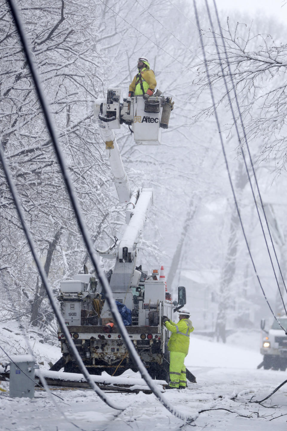 <p>Utility workers use a bucket truck to repair downed power lines along Mountainside Drive on March 7, 2018, in Morristown, N.J. Residents saw a second storm after last week’s storm downed trees and power lines. (Photo: Julio Cortez/AP) </p>