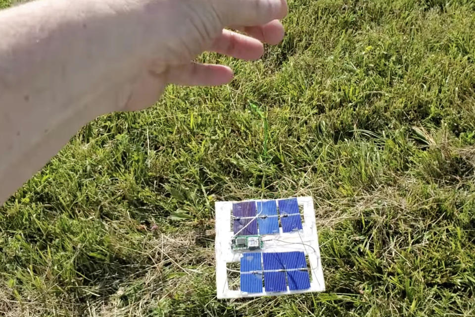 In this image taken from a video shot by Tom Medlin on June 11, 2022, Medlin shows electronics attached to a pico balloon, which costs about $12 and is about 32 inches in diameter, in a field near Collierville, Tenn. Medlin, owner of the Amateur Radio Roundtable podcast, believes a similar balloon is what the U.S. military shot down over the Yukon recently. Hobbyists typically fly the balloons for fun and to experience the challenge of building transmitters and antenna systems, although the National Oceanic and Atmospheric Administration has been collecting data from operators to learn more about wind patterns, he said. (Tom Medlin via AP)