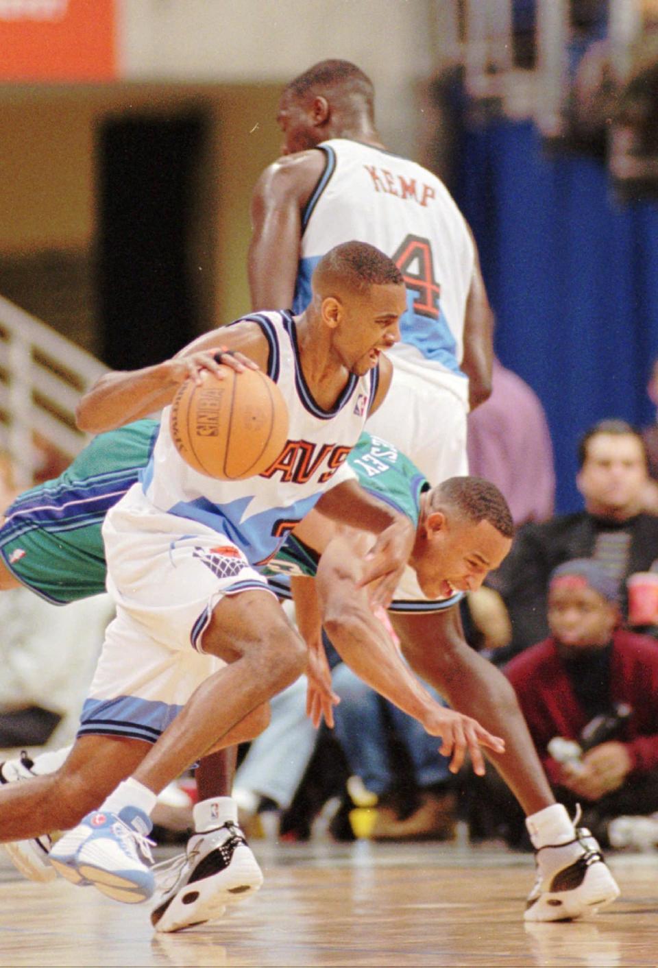 Cleveland Cavliers guard Derek Anderson (23) drives the ball toward the basket as Charlotte Hornets guard David Wesley, center, gets trapped in the middle between Anderson and Cleveland's Shawn Kemp (4) in the second quarter Saturday, Dec. 13, 1997, at the Gund Arena in Cleveland.