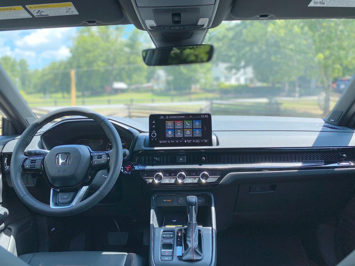 The front dash of a 2025 Honda CR-V Hybrid Sport Touring SUV with a 9-inch infotainment screen.