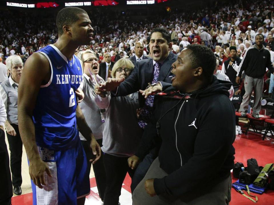 Kentucky guard Aaron Harrison (2) and an Arkansas fan who had stormed the court exchanged words at the Bud Walton Arena following the Razorbacks’ 87-85 overtime victory over the Wildcats on Jan. 14, 2014.