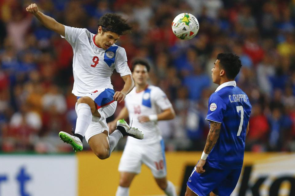 Charyl Yannic Chappuis (R) of Thailand looks as Misagh Medina Bahadoran of Philippines jumps for the ball during their second leg semi final match of AFF Suzuki Cup 2014 in Bangkok December 10, 2014. REUTERS/Damir Sagolj (THAILAND - Tags: SPORT SOCCER)