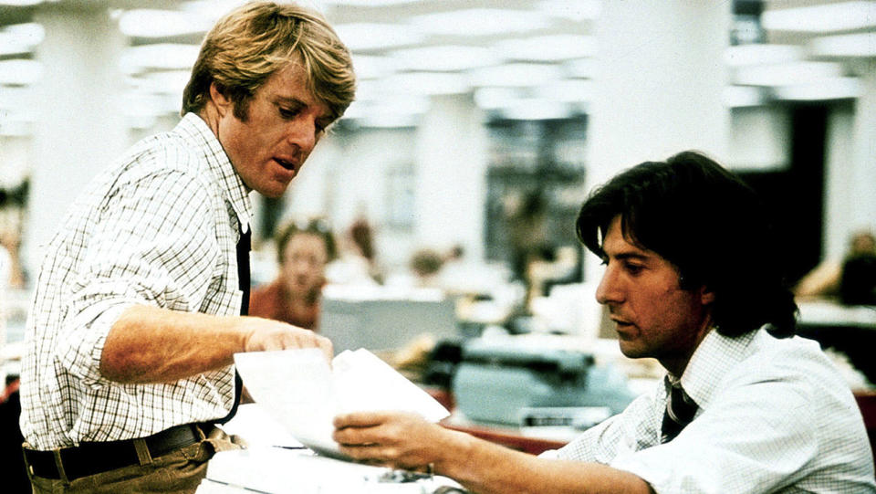 A still from All the President's Men shows Robert Redford and Dustin Hoffman looking over papers in a newspaper office