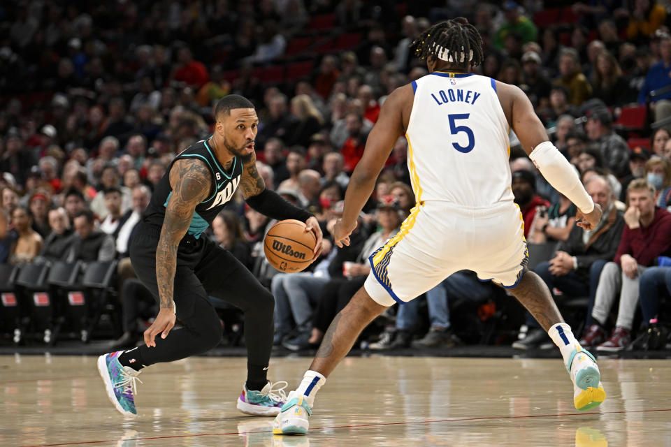 PORTLAND, OREGON - FEBRUARY 08: Damian Lillard #0 of the Portland Trail Blazers dribbles against Kevon Looney #5 of the Golden State Warriors during the first quarter at the Moda Center on February 08, 2023 in Portland, Oregon. NOTE TO USER: User expressly acknowledges and agrees that, by downloading and or using this photograph, User is consenting to the terms and conditions of the Getty Images License Agreement. (Photo by Alika Jenner/Getty Images)