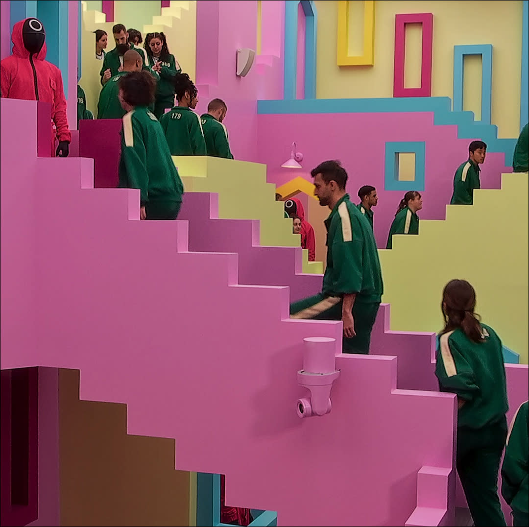  Players walk up a staircase in squid game the challenge netflix. 