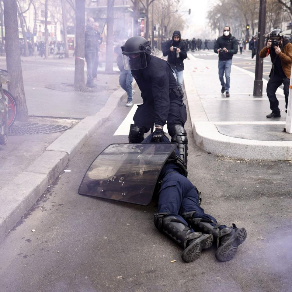 French police officers protect a colleague injured during clashes with protesters in Paris - YOAN VALAT/EPA-EFE/Shutterstock