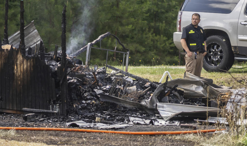 Fire and law enforcement investigators work on the scene of a house fire in Newnan, Ga. on Monday, June 17, 2024. (John Spink/Atlanta Journal-Constitution via AP)