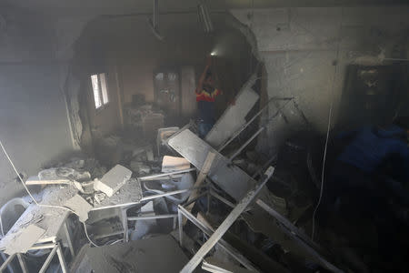 A Palestinian man gestures as he inspects a building hit by an Israeli air strike, in the southern Gaza Strip May 5, 2019. REUTERS/Ibraheem Abu Mustafa