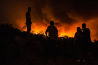 <p>People stand next to the fire before being evacuated at the village of Monchique, in southern Portugal’s Algarve region, Sunday, Aug. 5 2018. (Photo: Javier Fergo/AP) </p>