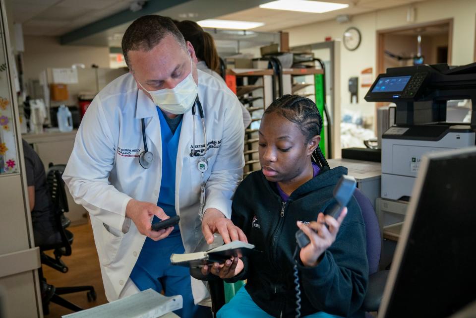 Emergency room Dr. Alexander Madgy, left, works with ER  clerk Kenya Fair as some choose to mask while others at Trinity Health Oakland Hospital in Pontiac on April 21, 2023. They have relaxed their masking mandates for staff and patients.