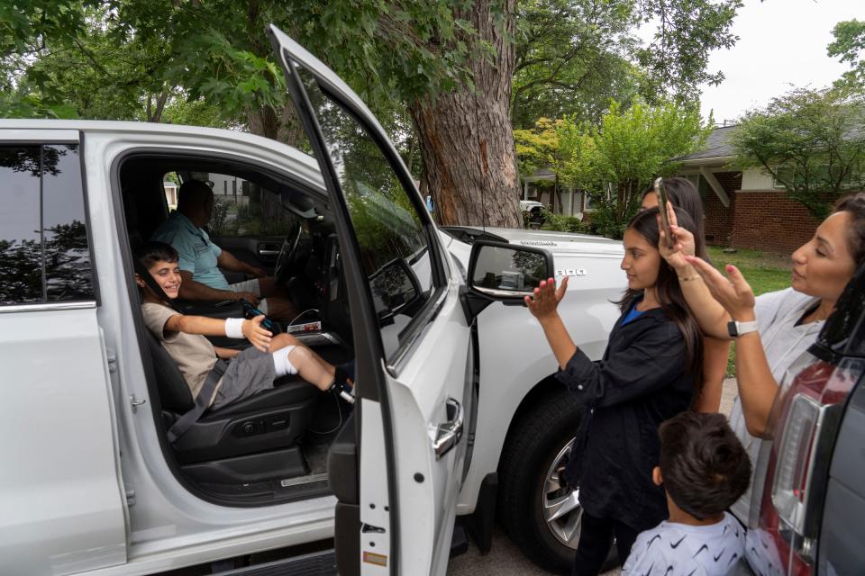 Saleh Humaid, 8, of Gaza, left, smiles as Laila Elabed, of Dearborn, right, and her daughter Alra Elabed waive goodbye as he leaves to return to his country after being hosted by the Hamed family in Dearborn Heights on Wednesday, Aug. 9, 2023, while staying in the United States to receive a prosthetic leg and rehabilitation.