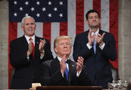 FILE PHOTO - U.S. President Donald Trump applauds in front of U.S. Vice President Mike Pence (L) and Speaker of the House U.S. Rep. Paul Ryan (R-WI) during his first State of the Union address to a joint session of Congress inside the House Chamber on Capitol Hill in Washington, U.S., January 30, 2018. REUTERS/Win McNamee/Pool