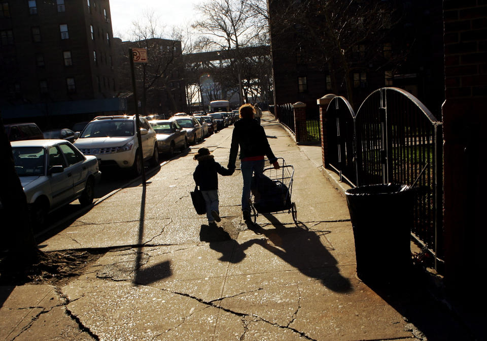 A mother holds hands with her daughter as they walk into their housing projects. (Photo: Ezra Shaw via Getty Images)