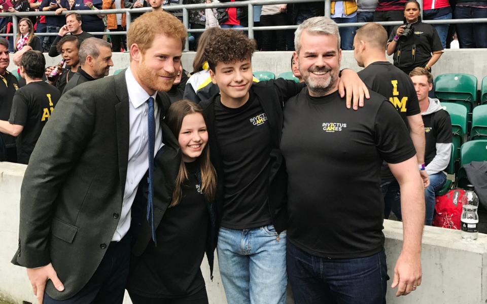 Prince Harry with Emily Briggs, 11, Isaac Briggs, 13, and Matt Briggs at Twickenham stadium in London, during the Army V Royal Navy annual rugby match.  - PA