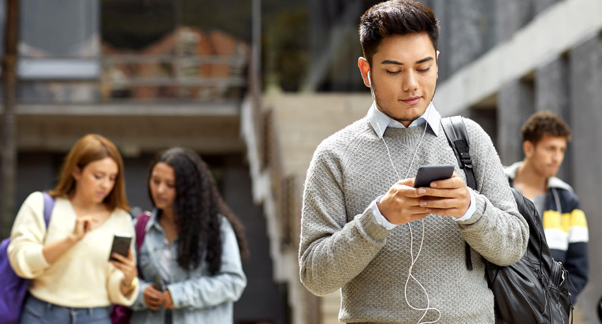 Young people leaving school using their phones, to represent looking at TikTok content. (Getty Images)