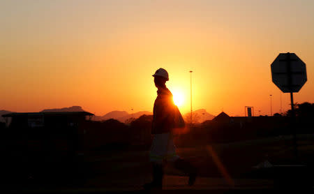 FILE PHOTO: A miner returns from his shift in Nkaneng township outside the Lonmin mine in Rustenburg, northwest of Johannesburg, June 26, 2015. REUTERS/Siphiwe Sibeko/File Photo