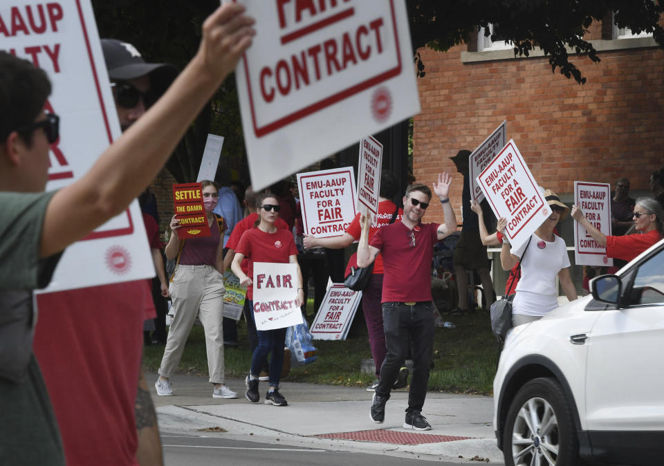 Picketing professors and their supporters hold signs in front of Welch Hall at Eastern Michigan University in Ypsilanti, Mich., on Wednesday, Sept. 7, 2022. Several dozen faculty at Eastern Michigan University began a strike Wednesday after their union and the school's administration failed to agree on a new labor contract. (Daniel Mears/Detroit News via AP)