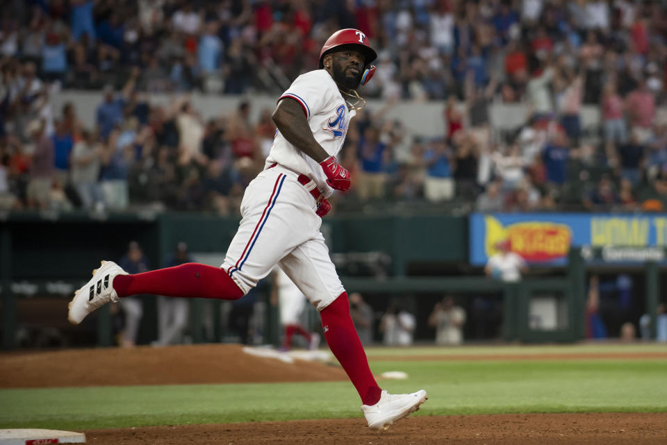 Adolis García, de los Rangers de Texas, trota alrededor de las bases después de batear un cuadrangular solitario en la parte baja de la séptima entrada, en el juego de béisbol en contra de los Astros de Houston, en Arlington, Texas, el lunes 3 de julio de 2023. (AP Foto/Emil T. Lippe)