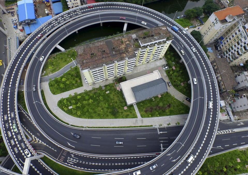 An old residential building is seen surrounded by a newly-built ring viaduct, in Guangzhou, Guangdong province, China, June 18, 2015. The building was planned to be demolished, but several units in the building refused to move out as they couldn't reach a compensation agreement with the authority, local media reported. Picture taken June 18, 2015. REUTERS/Ma Qiang/Southern Metropolis Daily CHINA OUT. NO COMMERCIAL OR EDITORIAL SALES IN CHINA           TPX IMAGES OF THE DAY     