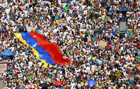 Opposition supporters hold a Venezuelan flag as they take part in a rally against Venezuelan President Nicolas Maduro's government in Caracas, Venezuela February 2, 2019. REUTERS/Adriana Loureiro