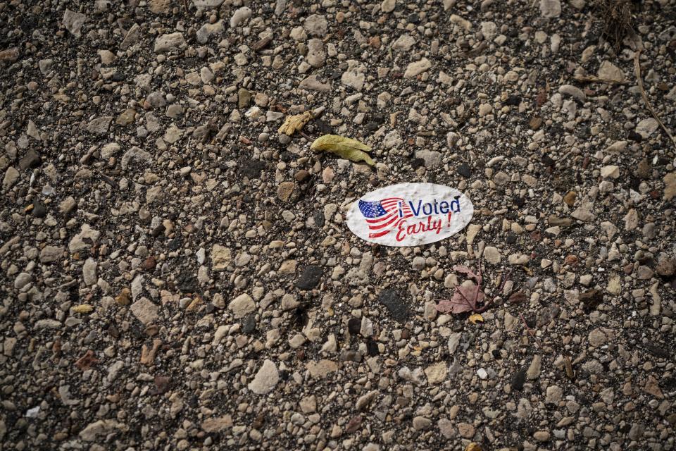 A sticker for early voters is stuck onto a pavement outside Kenosha's municipal offices for early voting, Friday, Oct. 30, 2020, in Kenosha, Wis. Trump has made protest violence in Kenosha and other American cities, a key part of his re-election campaign, linking violence to Democrats and saying it would spread dramatically if Democratic nominee and former Vice President Joe Biden was to defeat him on Election Day. (AP Photo/Wong Maye-E)