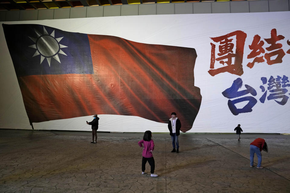 Children play in front of an image of a Taiwanese national flag as votes are counted in New Taipei City, Taiwan, Saturday, Jan. 13, 2024. Polls closed Saturday after Taiwanese cast their votes for a new president and legislature in an election that could chart the trajectory of the self-ruled democracy's relations with China over the next four years. (AP Photo/Ng Han Guan)