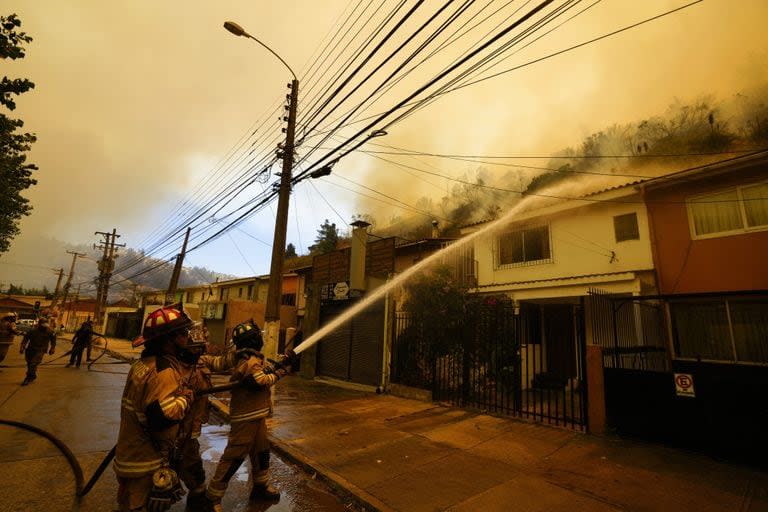 Los bomberos luchan contra el fuego en una casa en Viña del Mar. (AP Photo/Esteban Felix)