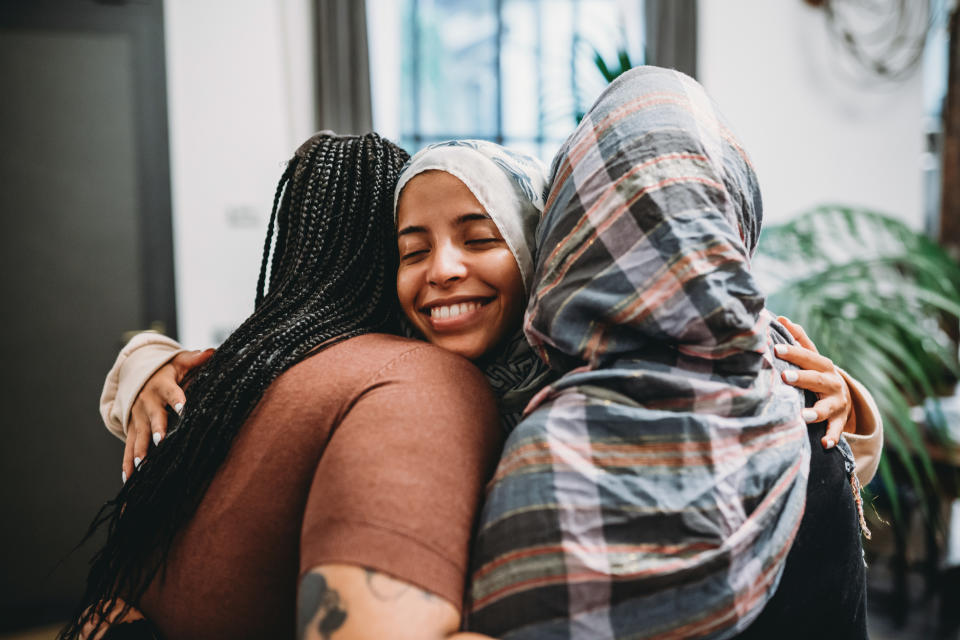 a group of three women hugging