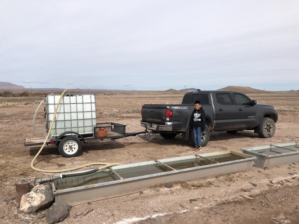 Shanna Yazzie's 10-year-old son stands by the family's truck as water for their use is pumped from a nearby windmill. (Photo: Courtesy of Shanna Yazzie)