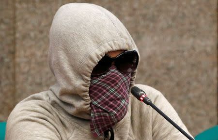 A woman wearing mask, whose father and mother were alleged by police as drug pushers and were both killed during an illegal drugs "meth raid", testifies regarding people killed during a crackdown on illegal drugs during a Senate hearing in Pasay, Metro Manila, Philippines August 23, 2016. REUTERS/Erik De Castro