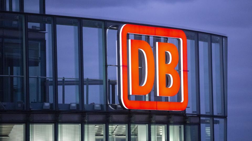 Das Logo der Deutschen Bahn AG ist in der Abenddämmerung am Bahntower am Potsdamer Platz zu sehen. Foto: Christoph Soeder