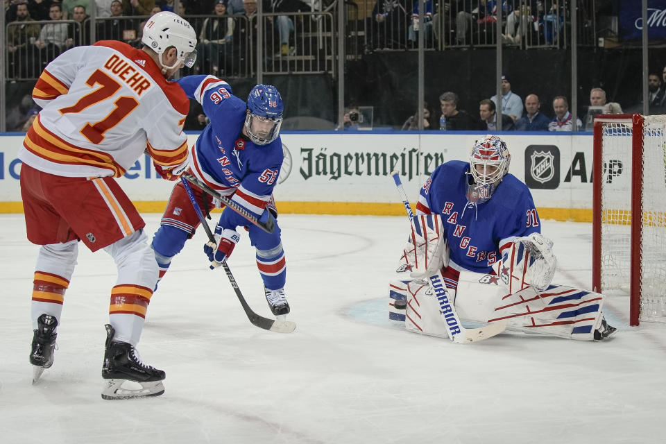 New York Rangers goaltender Igor Shesterkin (31) blocks a shot by Calgary Flames right wing Walker Duehr (71) during the third period an NHL hockey game on Monday, Feb. 12, 2024, in New York. (AP Photo/Bryan Woolston)