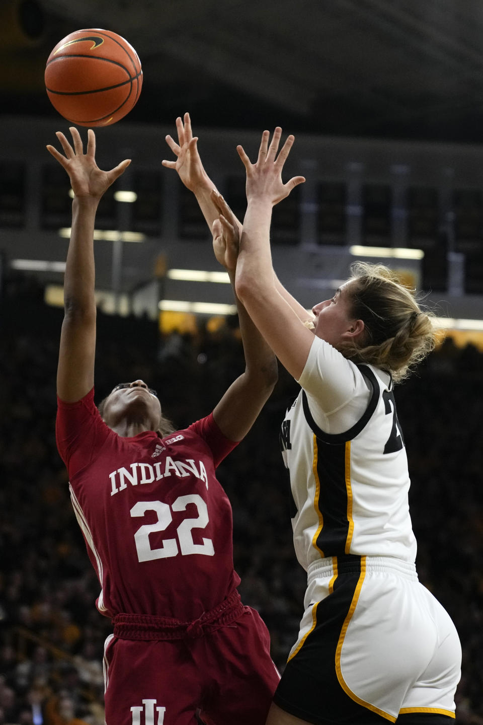 Indiana guard Chloe Moore-McNeil (22) is fouled by Iowa guard Kate Martin while driving to the basket during the first half of an NCAA college basketball game, Sunday, Feb. 26, 2023, in Iowa City, Iowa. (AP Photo/Charlie Neibergall)