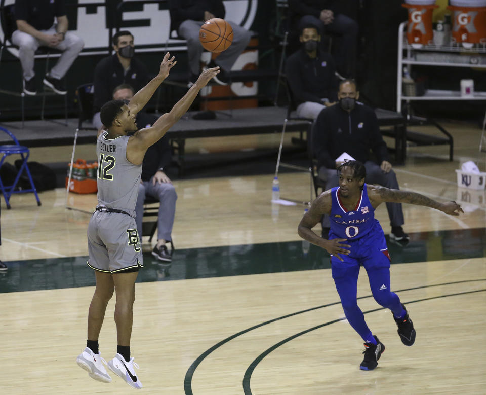 Baylor guard Jared Butler (12) shoots a three-point basket past Kansas guard Marcus Garrett (0) in the first half of an NCAA college basketball game, Monday, Jan. 18, 2021, in Waco, Texas. (AP Photo/Jerry Larson)